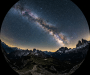 Milky Way galaxy arcing over rocky mountain peaks under a clear night sky filled with stars